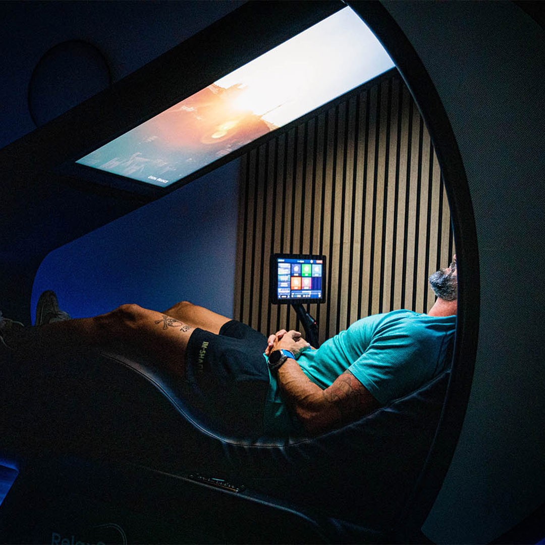 Man laying down in a relaxation pod