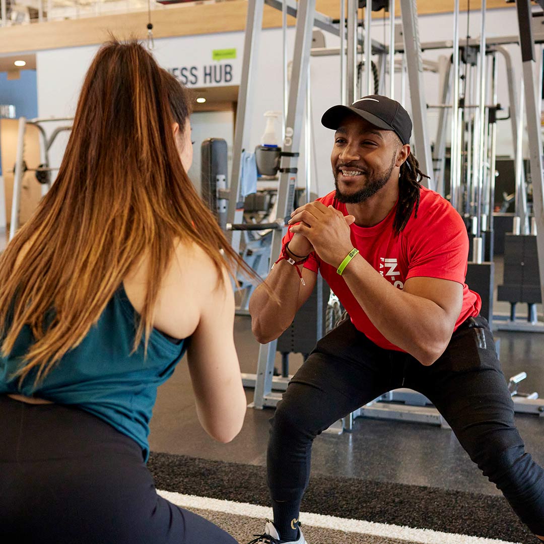 personal trainer and client performing body weight squats