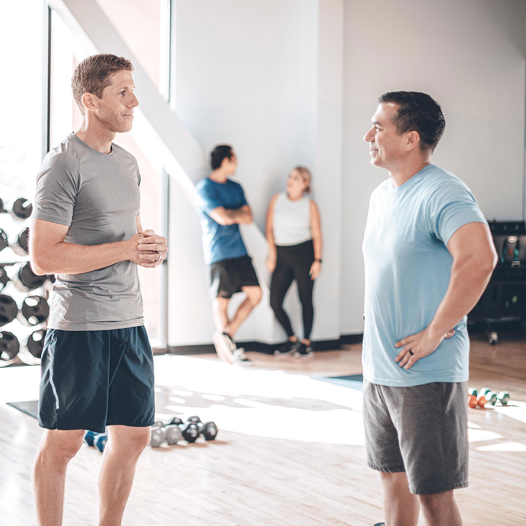 two men talking in the gym