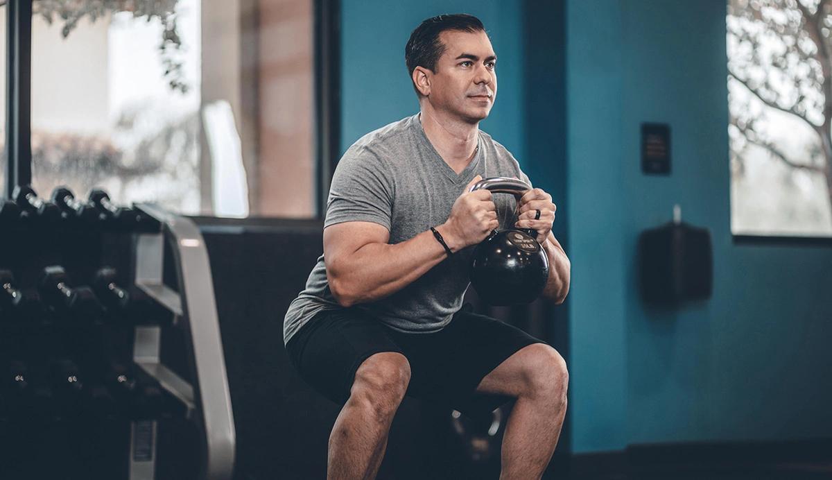Man performing a kettlebell squat